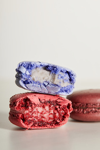 selective focus of assorted delicious bitten colorful french macaroons on white background