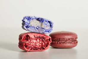 selective focus of assorted delicious bitten colorful french macaroons on white background
