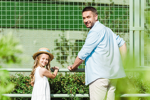 selective focus of cheerful father and daughter  in zoo