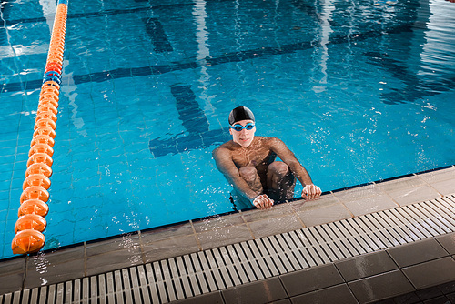 handsome swimmer in swimming cap  in swimming pool