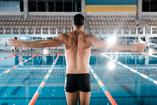 back view of swimmer standing with outstretched hands