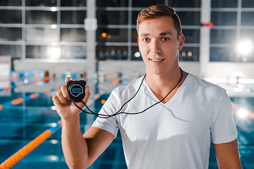 happy trainer in white t-shirt holding timer