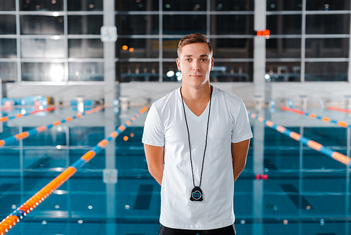 cheerful trainer  while standing near swimming pool