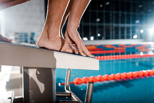 cropped view of athletic sportsman standing on diving block