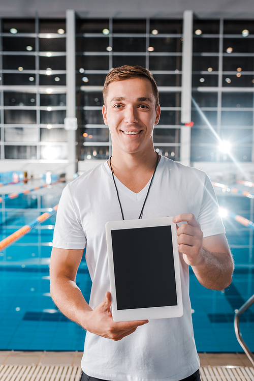 smiling trainer holding digital tablet with blank screen