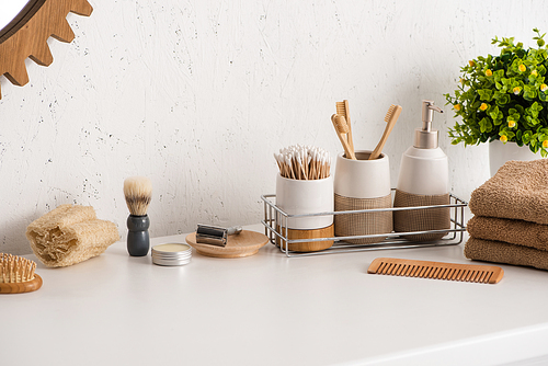Different beauty and hygiene objects with flowerpot in bathroom, zero waste concept