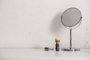 Round mirror, shaving brush and razor on white background, zero waste concept