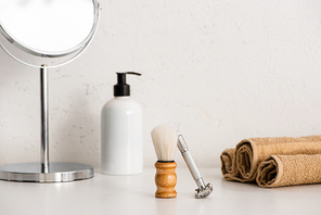 Round mirror, dispenser body cream, shaving brush, razor and towels on white background, zero waste concept