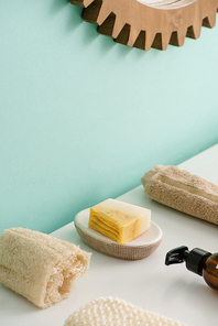 Selective focus of loofah, bottle of eco body cream, soap and towel in bathroom, zero waste concept