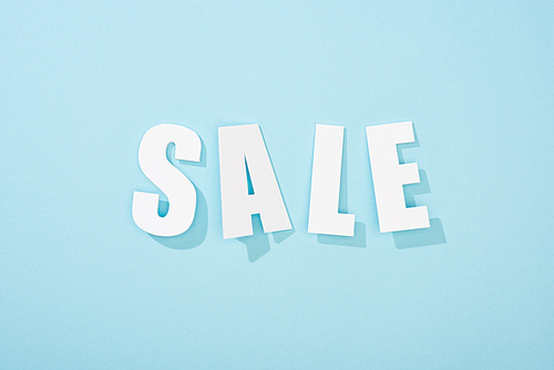 top view of white sale lettering on light blue background