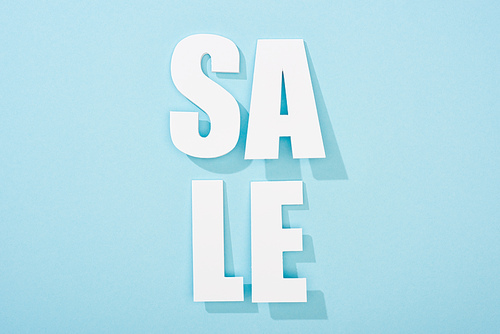 top view of white sale lettering on blue background with copy space