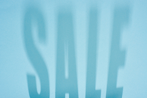 shadow of sale lettering on light blue background