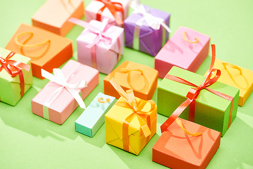 selective focus of decorative colorful gift boxes on green background