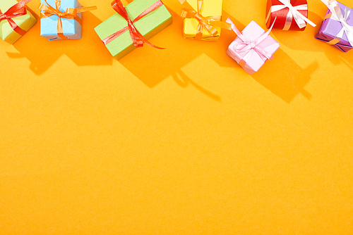 top view of festive wrapped gifts on bright orange background