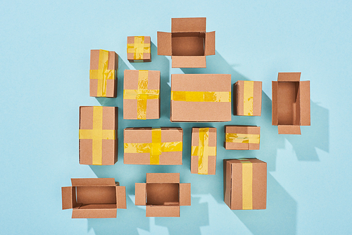 top view of closed and open cardboard boxes on blue background