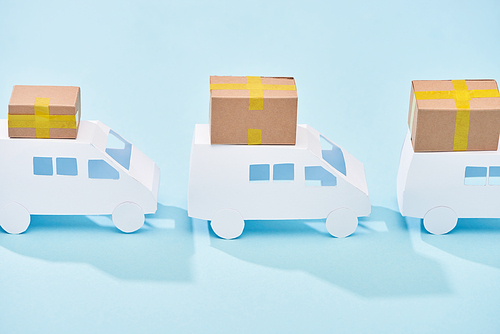 white mini vans with closed cardboard boxes on blue background
