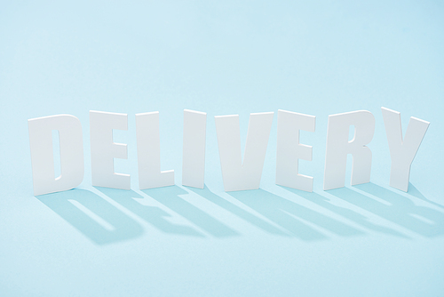 delivery lettering with shadow on blue background with copy space