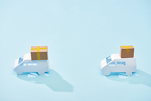 white mini vans with cardboard parcels on blue background