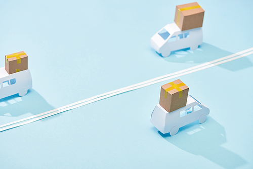 miniature white trucks with parcels on blue background with double line