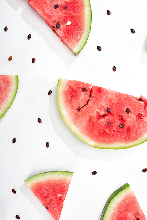 top view of delicious watermelon slices with seeds on white background
