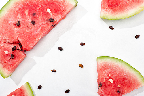 top view of juicy watermelon slices with seeds on white background