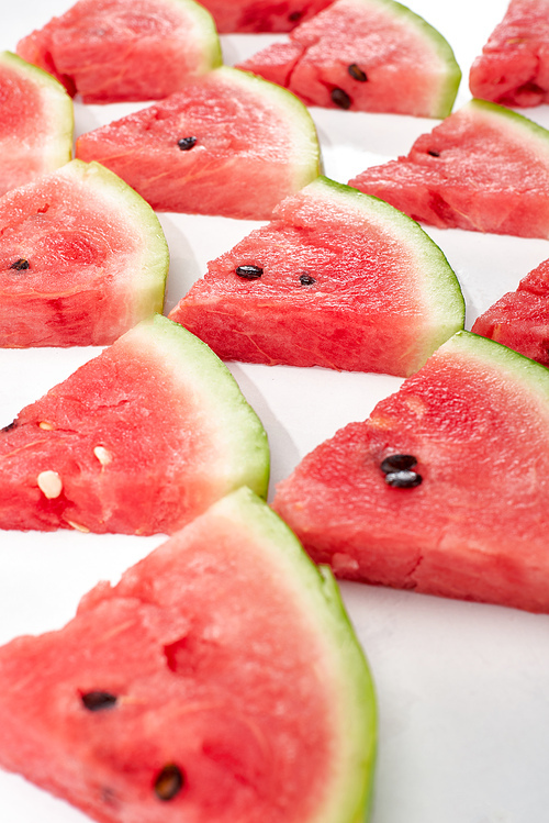 delicious juicy watermelon slices in rows on white background