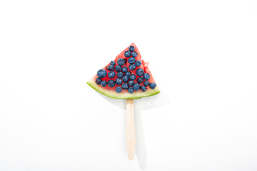 top view of delicious watermelon on stick with blueberries on white background
