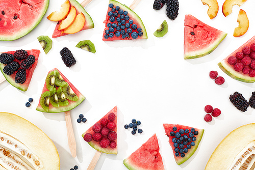 top view of delicious juicy watermelon on sticks with seasonal berries and fruits on white background with copy space