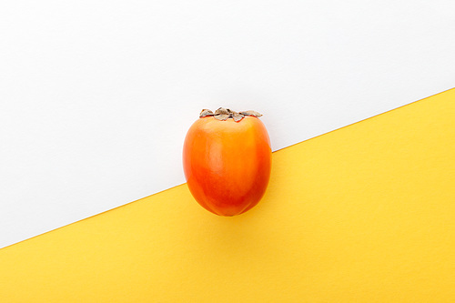 Top view of persimmon on white and yellow background