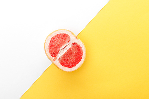 Top view of grapefruit half on yellow and white background