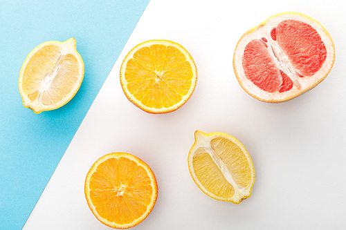 Top view of citrus halves on white and blue background