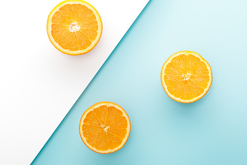 Top view of oranges halves on white and blue background