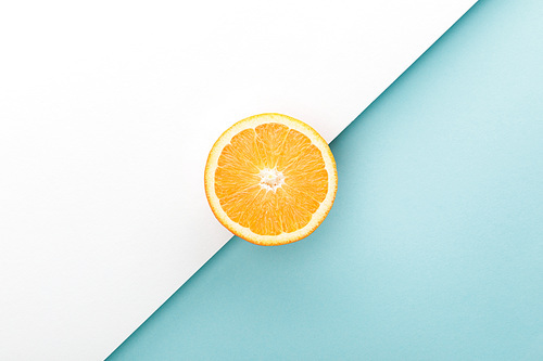 Top view of orange half on white and blue
