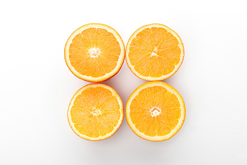 Top view of cut oranges on white background