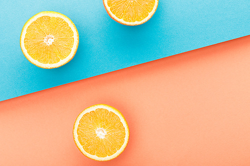 Top view of oranges halves on blue and orange background