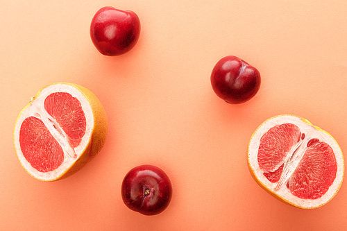 Top view of apples and grapefruit halves on white and orange background