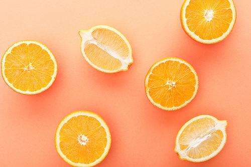 Top view of citrus fruits halves on orange background