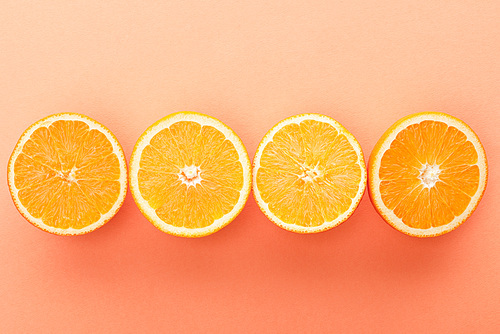 Top view of cut citrus fruits on orange background