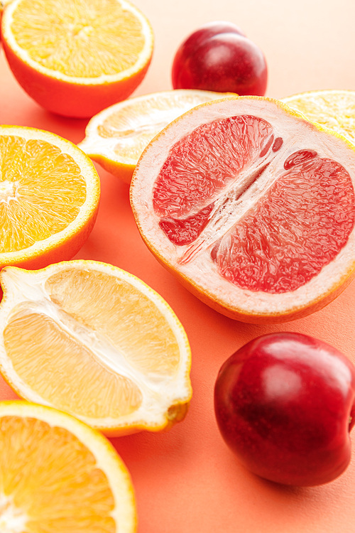 Citrus halves and apples on orange background