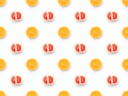 Top view of grapefruits halves and orange slices on white background