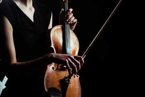 partial view of female musician playing on violin isolated on black