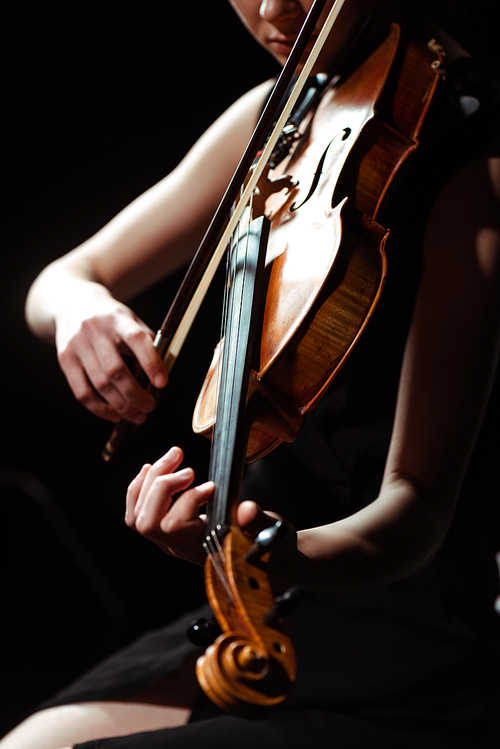 partial view of musician playing symphony on violin isolated on black