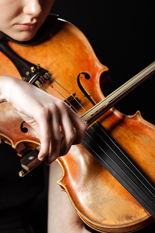 partial view of professional musician playing on violin isolated on black