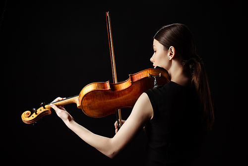 beautiful professional musician playing on violin isolated on black