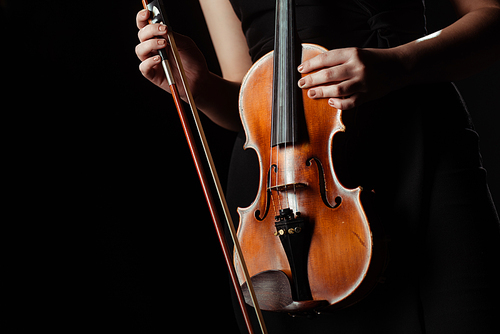partial view of musician holding violin isolated on black