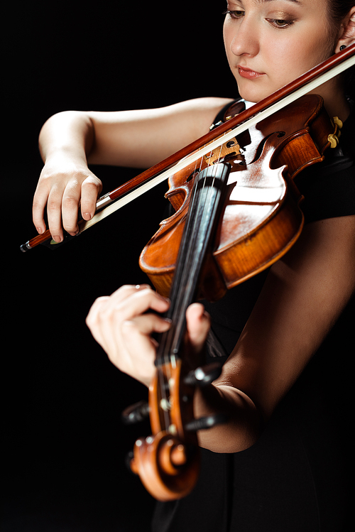attractive professional musician playing symphony on violin isolated on black