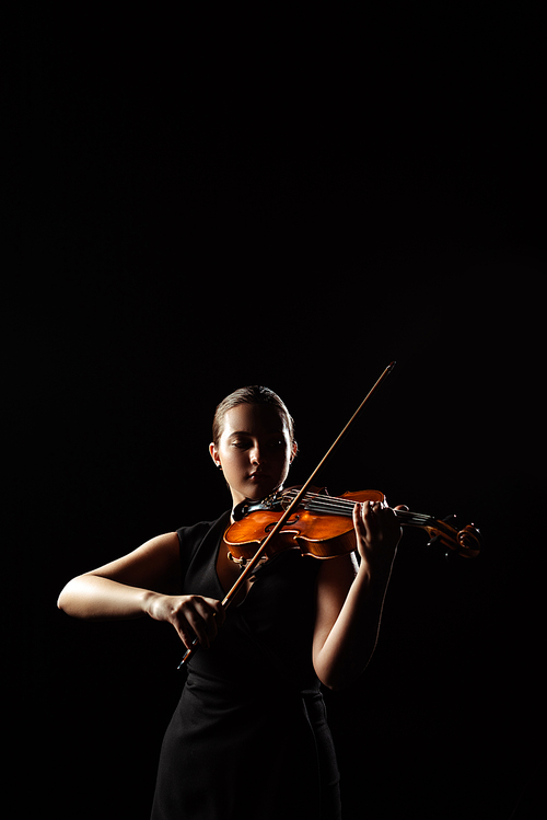 beautiful professional musician playing symphony on musical instrument isolated on black