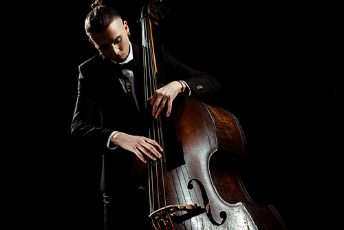 male musician playing on contrabass isolated on black