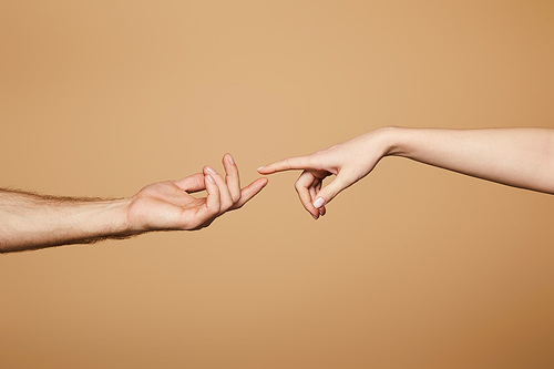 cropped view of man and woman reaching each other with fingers isolated on beige