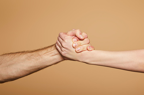 cropped view of man and woman holding hands isolated on beige